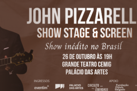 Imagem com um homem segurando o violão e sorrindo 