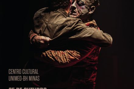 Imagem com o fundo preto, duas pessoas se abraçando