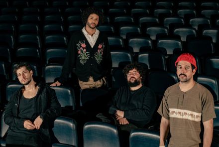 Foto da banda Zimbra, 4 integrantes no cenário de uma sala de cinema