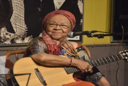 Imagem real de dona Jandira segurando um violão 