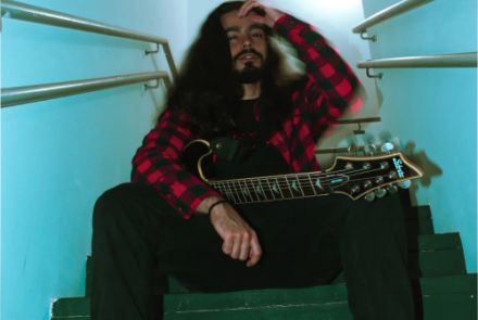 um homem na escada com uma guitarra na mão