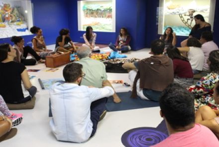 roda de pessoas juntas em ciruclo sentadas no chão 