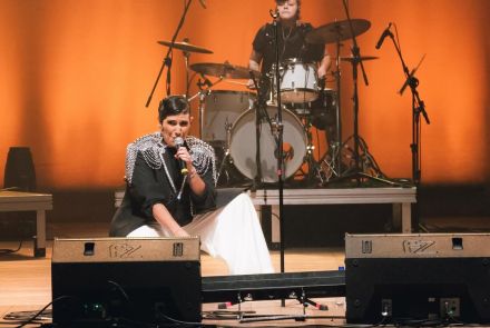 Fotografia da artista Amandona no palco se apresentando 