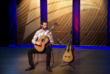 Foto do Gustavo Ramos no palco com dois violões.
