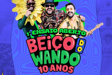 Cartaz colorido com fundo azul psicodélico anunciando o "1º Ensaio Aberto - Beiço do Wando 10 Anos". No centro, três homens sorridentes: um fantasiado de girassol, um de chapéu e óculos escuros, e outro tocando guitarra. Abaixo, as informações: "11 de Janeiro, Domingo, a partir das 10h", "DJ Zordan + Atrações" e o endereço em Belo Horizonte. No canto, o logo da Sympla indica ingressos gratuitos.