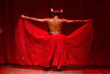 Imagem de um homem de costas com fantasia vermelha 