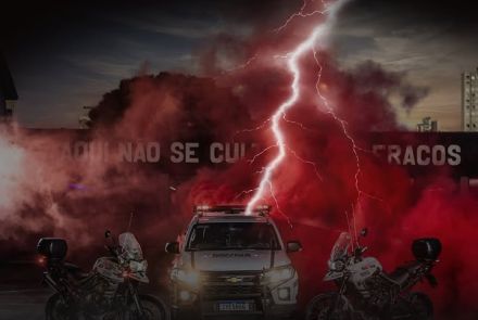 Flyer do carro e moto da policia militar de fundo com o titulo do evento, data e local. 