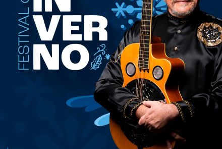 Cartaz do Festival de Inverno com o cantor Zé Ramalho. Ele aparece sorrindo e segurando um violão, vestindo uma camisa preta com bordados dourados. O fundo é azul com desenhos de flocos de neve e pinheiros.
