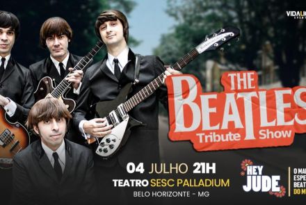 Quatro homens vestidos de terno preto, estilo anos 1960, seguram instrumentos musicais e posam como uma banda.