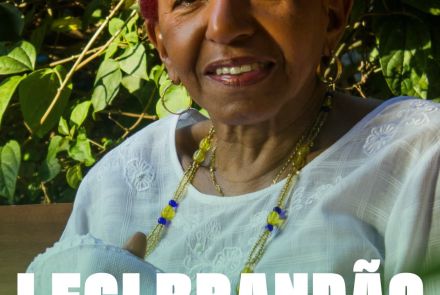 Leci Brandão na Autêntica Imagem vertical com fotografia em close da cantora Leci Brandão, uma mulher negra sorridente com cabelos curtos vermelhos, vestindo blusa branca rendada e colares de contas. Ao fundo, folhagens verdes. Na parte inferior, sobrepostas à foto, estão as informações em branco: o nome "Leci Brandão" em destaque, seguido por "DJ Camis", a data "Sábado, 04.07, 21h", o local "Belo Horizonte" e o link de ingressos "sympla.com.br/autentica". No rodapé, a logomarca da casa de sho