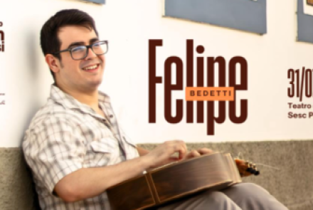 Imagem do cantor com o violão no colo 