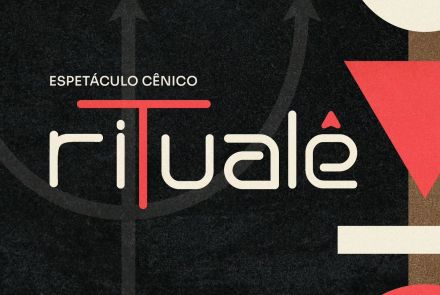Cartaz com fundo grafite escuro onde se lê ao centro "ESPETÁCULO CÊNICO ritualê". A palavra "ritualê" tem letras brancas arredondadas, com o "t" destacado em vermelho formando um portal e o "ê" com acento em forma de seta. Ao fundo, há o desenho discreto de um tridente cinza. Na lateral direita, destaca-se uma coluna com formas geométricas coloridas empilhadas: círculo azul, lua branca, triângulo invertido vermelho, bloco branco e semicírculo vermelho.