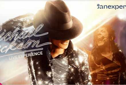 Banner horizontal com fundo de luzes azuis e douradas destaca um sósia de Michael Jackson em duas poses de show: no centro, sorrindo de perfil com chapéu fedora preto e jaqueta de lantejoulas brilhantes; à direita, ao fundo, cantando ao microfone. No lado esquerdo, lê-se em letras cursivas e luminosas "Michael Jackson - LIVE EXPERIENCE". No canto superior direito está a marca "sanexperience" e, no canto inferior esquerdo, um detalhe rosa-choque.