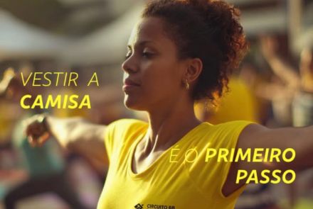 Cartaz do Circuito BB de Corrida de Rua 2026 – Etapa Belo Horizonte (02.08), com percursos de 1K, 5K e 10K. A imagem mostra uma mulher negra alongando ao ar livre vestindo a camiseta amarela do evento. Sobre a foto, a frase motivacional: "Vestir a camisa é o primeiro passo da vitória imaginada". No topo, logos e detalhes da prova.