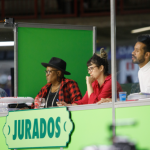 Imagem de pessoas jurados em uma bancada de avaliação do arraial de BH 2025