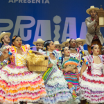 Imagem de um grupo de quadrilha junina se apresentando no Arraial de Belô